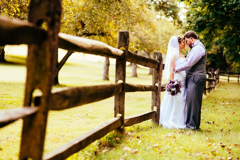 Bride and Groom leaning on the fence at historic Ephrata Cloister